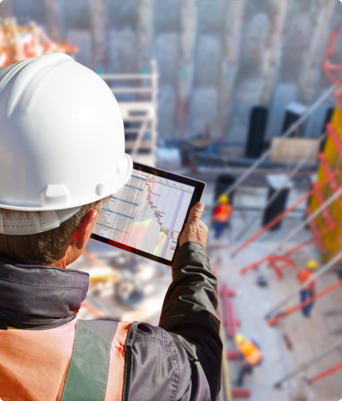 Construction engineer reviewing a project schedule on a tablet at an active jobsite